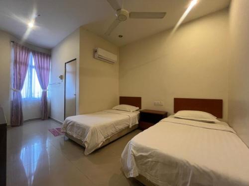 a bedroom with two beds and a window at Hotel O Kledang Menglembu in Ipoh