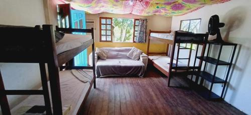 a room with two bunk beds and a chair at Hostel Kay Pacha e Camping in Maceió