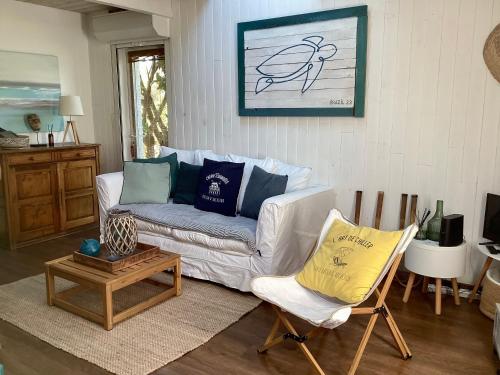 a living room with a couch and a chair at La cabane du littoral in La Teste-de-Buch