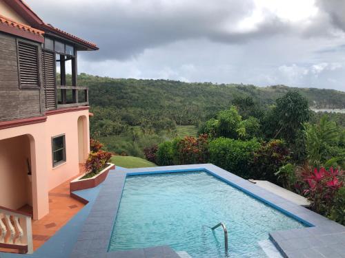 a swimming pool in front of a house at Fond Bay Suites Hotel - Breathtaking Ocean Views in Micoud