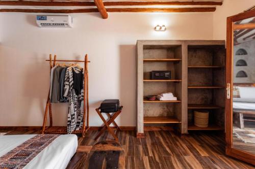 a room with a bed and a closet with a mirror at Ananda Beach Hotel in Paje