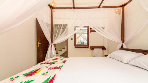 a bedroom with a white bed and a window at Caspiro Villa in Habaraduwa Central