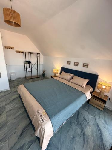 una camera da letto con un letto grande con testiera blu di SummerBlue - Синьо лято a Lozenets