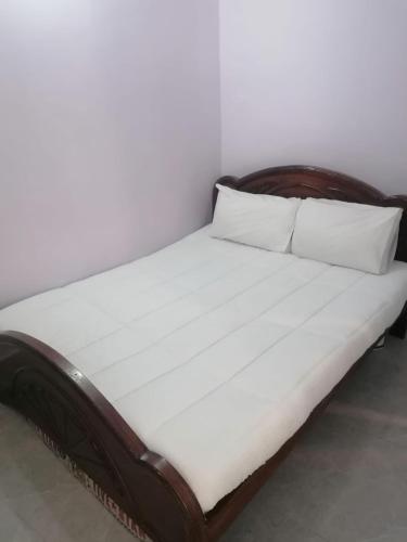 a bed with white sheets and pillows in a room at Mount Murree Hotel in Murree