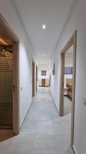 a hallway with two doors and a room with a bed at Appartement luxueux - Piscines, Plage 300m, Résidence fermée in Martil