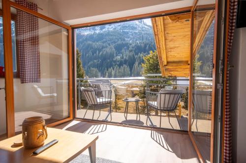 a room with a balcony with chairs and a table at Appartement Alpenliebe in Bichlbach