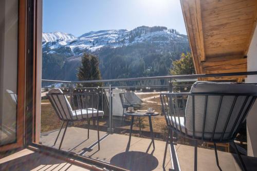 a balcony with chairs and a view of a mountain at Appartement Alpenliebe in Bichlbach