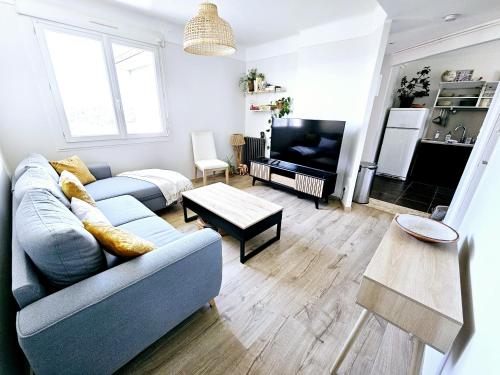 un salon avec un canapé et une télévision dans l'établissement L'Ensoleillé - Central, Wifi & Confort, à Rodez