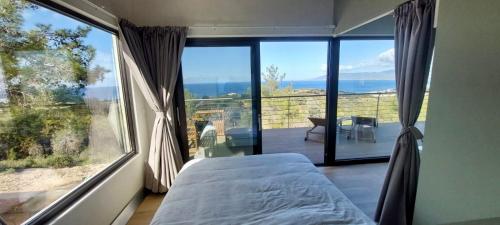a bedroom with a bed and a large window at Philip's Akamas Retreat in Neo Chorio