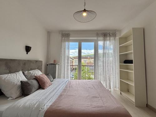 une chambre avec un grand lit avec une grande fenêtre dans l'établissement M57*Marquer* T3 proche frontière, à Annemasse