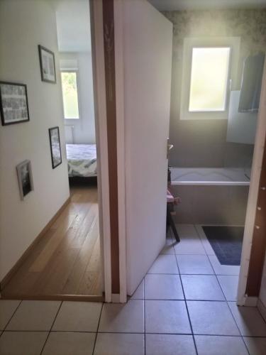 un couloir avec une pièce avec baignoire et une pièce avec dans l'établissement Appartement avec terrasse, à Guichen
