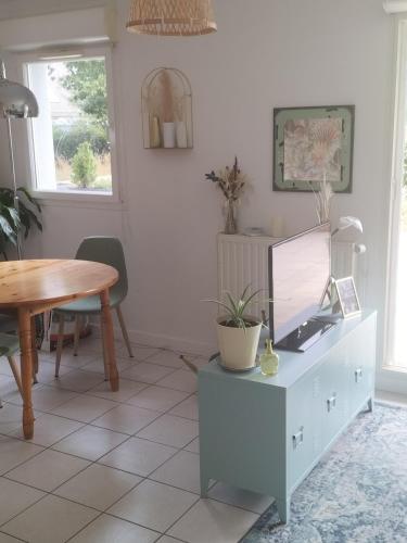 un salon avec une télévision sur une armoire dans l'établissement Appartement avec terrasse, à Guichen
