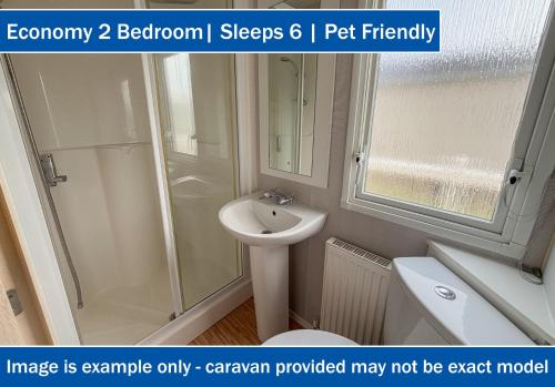 a bathroom with a shower and a sink and a toilet at Crows Nest Caravan Park in Filey
