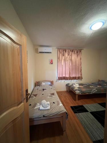 a small room with two beds and a window at Apartman Demirovic in Orašac
