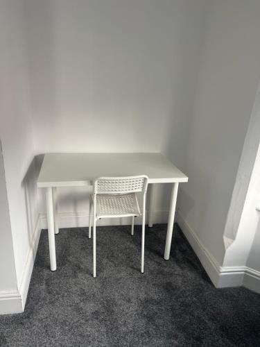 a white table and a chair in a room at Northumberland Road Studios in Coventry