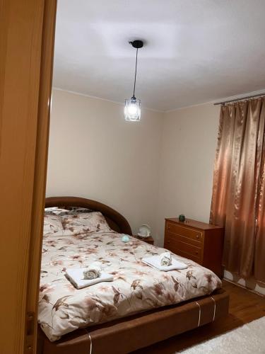 a bedroom with a bed and a dresser and a light at Apartman Demirovic in Orašac