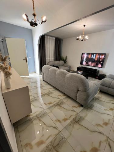 a living room with a couch and a flat screen tv at Sweet House Residence in Douala