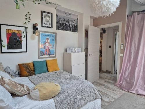 - une chambre avec un lit dans une pièce avec des photos sur le mur dans l'établissement Mas provençal avec grande piscine idéal 8 personnes ! # Welcome, à Piolenc