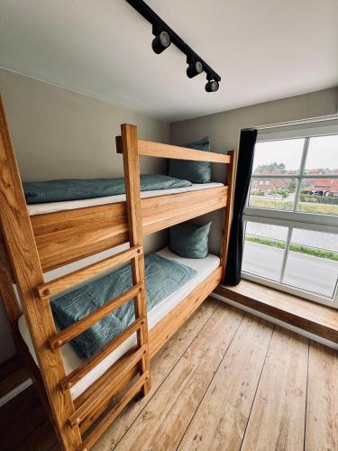 a bunk bed room with two bunk beds and a window at stilfrei by Humble Homes in Carolinensiel