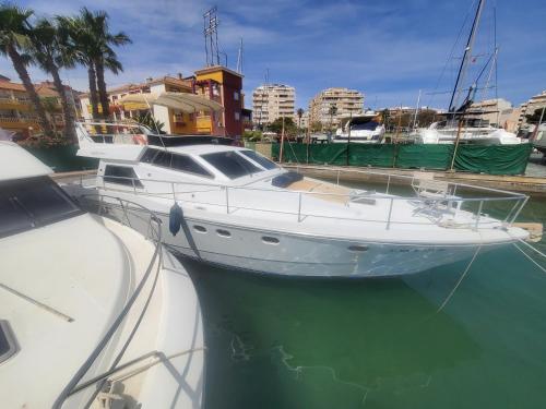 een witte boot is aangemeerd in het water bij Moonlight Lady, our secret on the Med! in Torrevieja