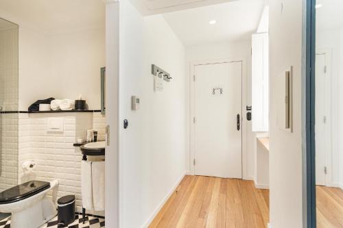 a white bathroom with a toilet and a sink at 1872 River House by Olivia in Porto