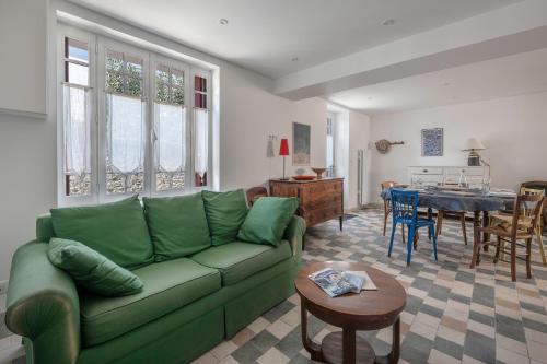 un salon avec un canapé vert et une table dans l'établissement Proche du port & plages - Terrasse - Maison pour 5, à Pornic