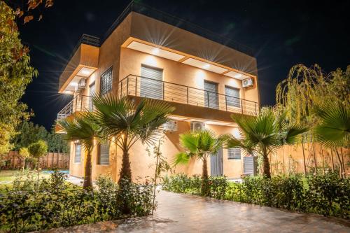 a building with palm trees in front of it at Villa Park Marrakech in El Aggada
