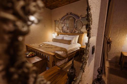 a bedroom with a bed and a mirror at The Kingdom Of Cappadocia Luxury Cave Hotel in Uchisar