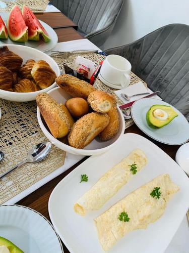 a table with plates of bread and pastries on it at Villa Piagne Bastos in Yaoundé