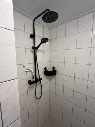 a shower with a shower head in a bathroom at Slapen bij Bartje in Assen