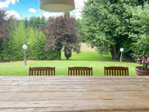 une table en bois avec quatre chaises dans un parc dans l'établissement Casale Geos, à Capannori