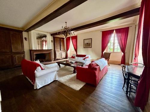 a living room with red and white furniture and a fireplace at Au Chateau, Luby- Betmont in Luby-Betmont