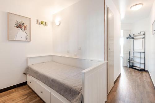 Ce lit se trouve dans un dortoir aux murs blancs. dans l'établissement Apartment with Garden, Pool, Sea View and Parking, à Cannes