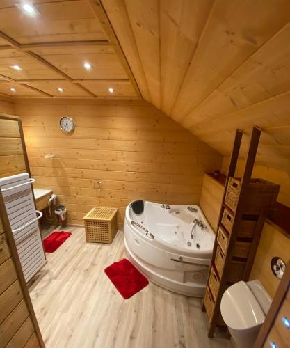 Cette chambre en bois comprend une salle de bains pourvue d'une baignoire. dans l'établissement Le Fenil-Logis Sauna Bain Nordique Salle cinéma, à Ban-sur-Meurthe-Clefcy