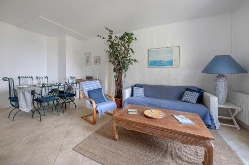 un salon avec un canapé bleu et une table dans l'établissement 20m de la mer - Terrasse - Appartement pour 6, à Pornic