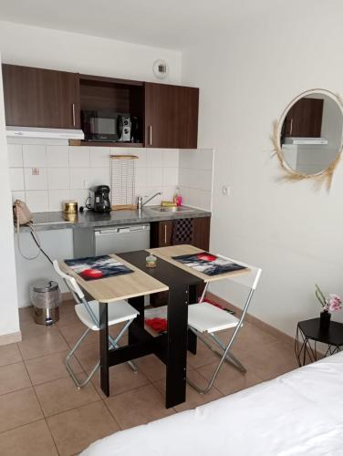une cuisine avec une table et des chaises dans une pièce dans l'établissement B201 Studio 10 min DisneyLand Paris, à Montévrain