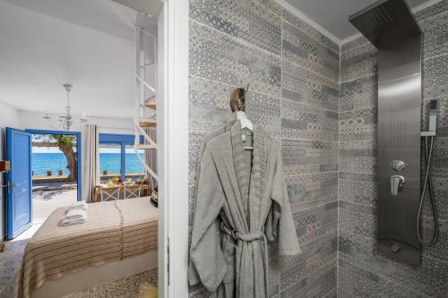 a bathroom with a robe hanging on a wall at Hermes Seaview House in Archangelos