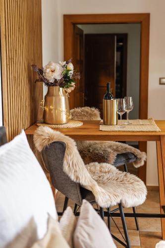a table with a vase of flowers and wine glasses at Apartmán Ranč in Martin