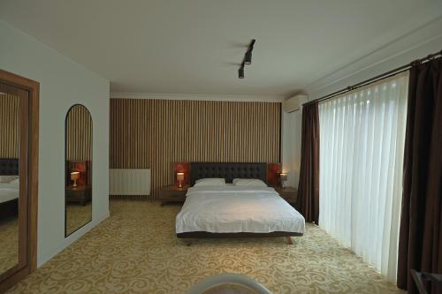 a bedroom with a bed and a large window at My Suit Residence & Hotel in Samsun