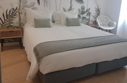 a bedroom with a large bed with white sheets and pillows at Vera Cruz Suite Apartment in Aveiro