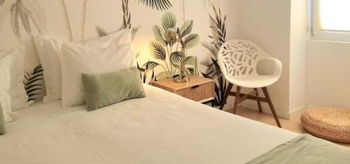 a bedroom with a bed and a chair and plants at Vera Cruz Suite Apartment in Aveiro