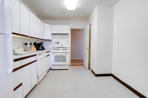 a white kitchen with white cabinets and appliances at Family-Sized 3BR Retreat Minutes from Reagan National in Arlington