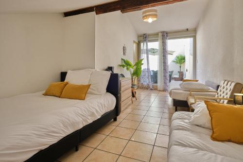 un salon avec deux lits et un canapé dans l'établissement Spacieux Appartement Climatisé au centre-ville de Narbonne, à Narbonne