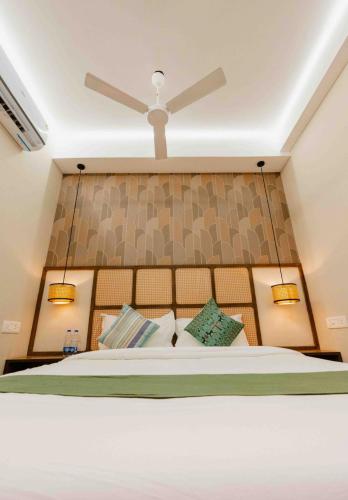 a bedroom with a bed with a ceiling fan at Hotel Kalos in Mahabalipuram