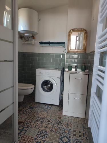 une salle de bain avec machine à laver et toilettes dans l'établissement Appartement cosy, à Béziers