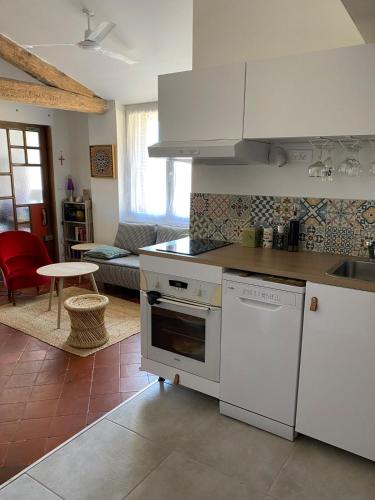 Il comprend un salon et une cuisine équipée d'appareils électroménagers blancs. dans l'établissement Appartement cosy, à Béziers