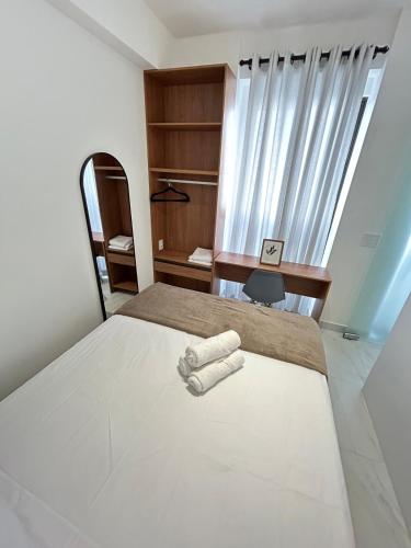a bedroom with a bed and a desk and a window at Melhores Flats - Encanto a 5 min da praia de Tambaú in João Pessoa