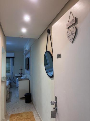 a room with a door with a clock on the wall at Flat Cavalinho Branco 119 in Águas de Lindoia