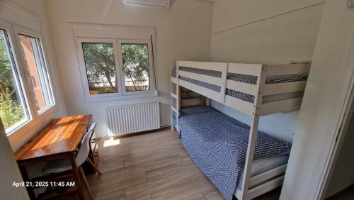 a room with bunk beds and a desk and a table at The Painter's Garden, Walk to Sea, Onsite Parking in Nea Makri