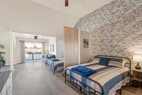 ein Schlafzimmer mit zwei Betten und einer Ziegelwand in der Unterkunft Sunset Serenity!!-Tropical Waterfront Oasis-Huge Private Patio-10Min to KingSt & Beaches in Charleston